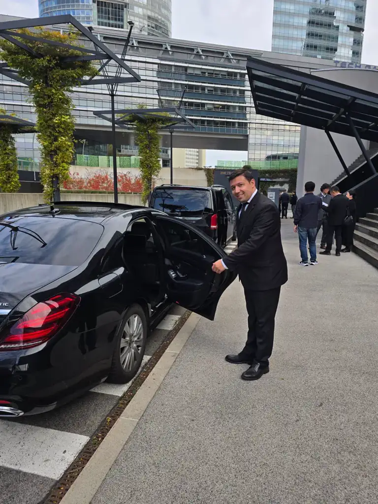 Private chauffeur opening a luxury car door for a passenger